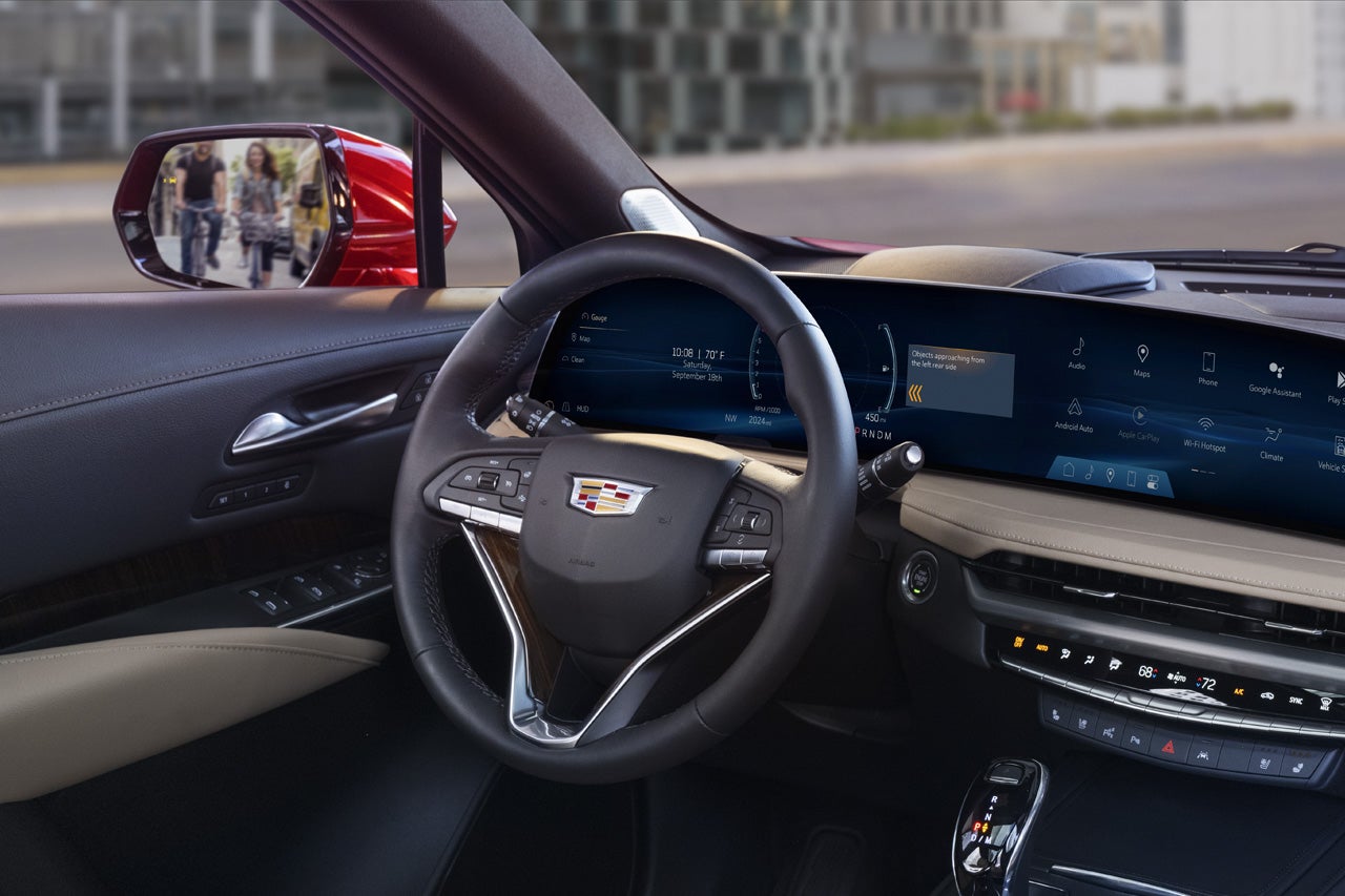 A Woman Utilizing the 2025 Cadillac XT5 Infotainment System Touch Screen